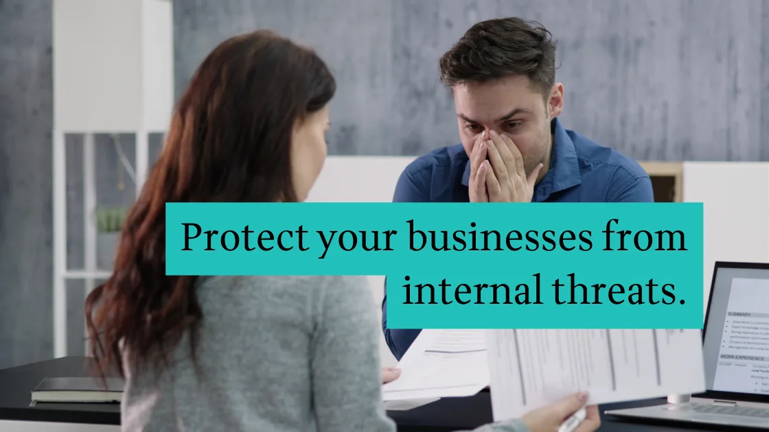 An employee being interviewed across a desk during an internal corporate investigation. Text overlay: Protect your businesses from internal threats.